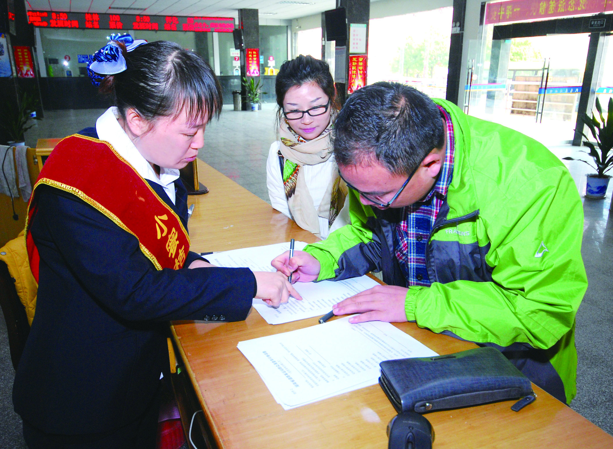 圖為洞口汽車總站站務(wù)人員在熱心為旅客服務(wù)。